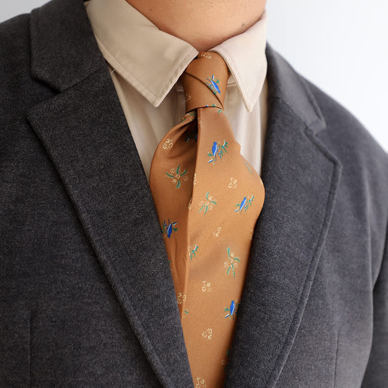 Cravate orange foncé pour homme avec oiseaux bleus et petites fleurs blanches