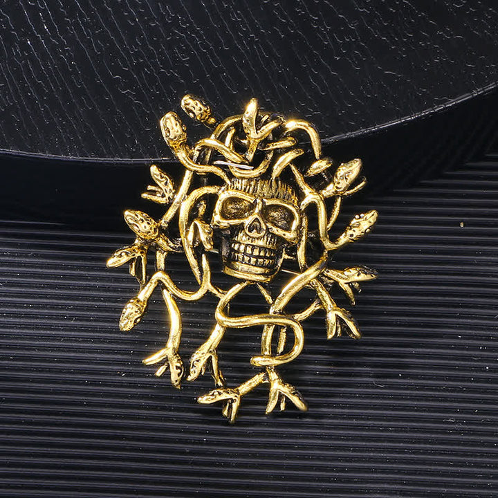Broche tête de mort exagérée enveloppée de serpent