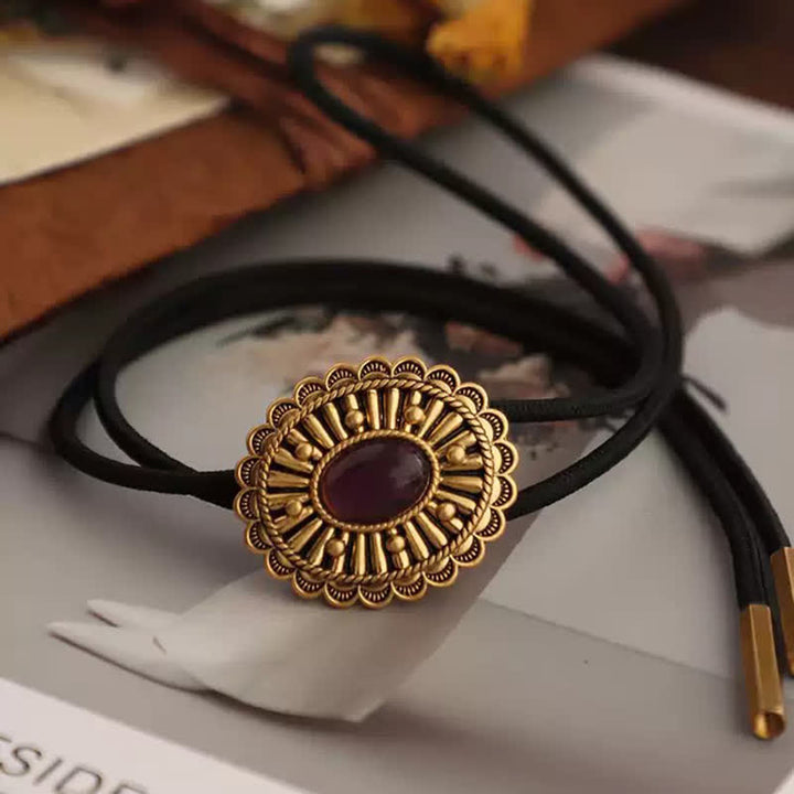 Cravate bolo en résine foncé rouge avec médaillon en or antique