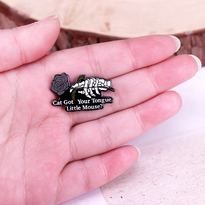 Broche en émail représentant un squelette de petite souris rose et un chat qui a pris ta langue