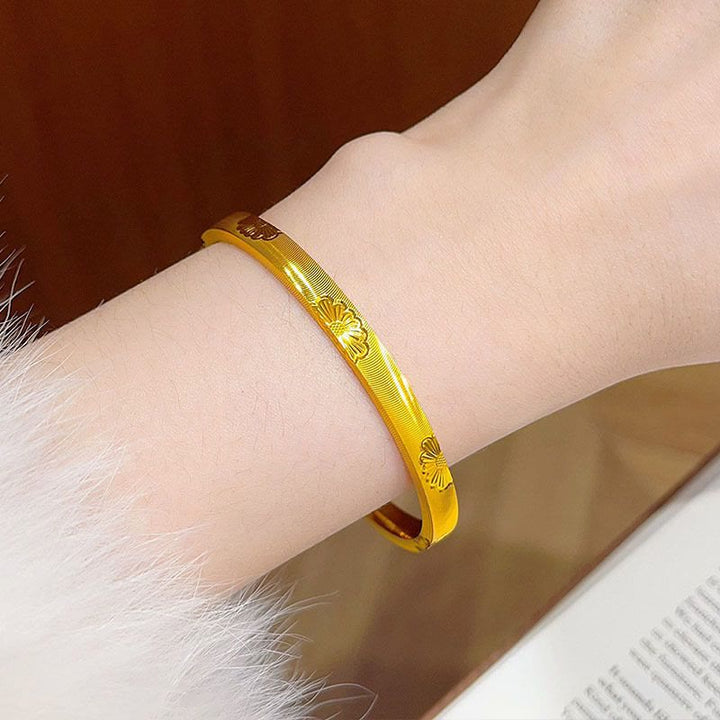Bracelet jonc fermé doré à motif marguerite et texture œil-de-chat pour femme - image 2